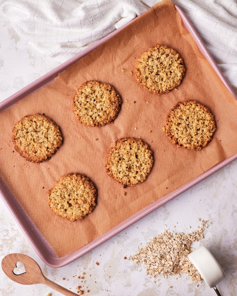 overhead view of oatmeal cookies on a cookie sheet. 