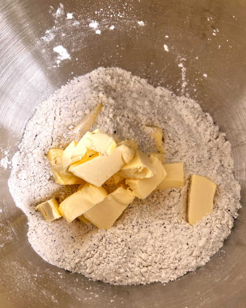 cubes of butter in bowl of flour mixture ready to make scones.