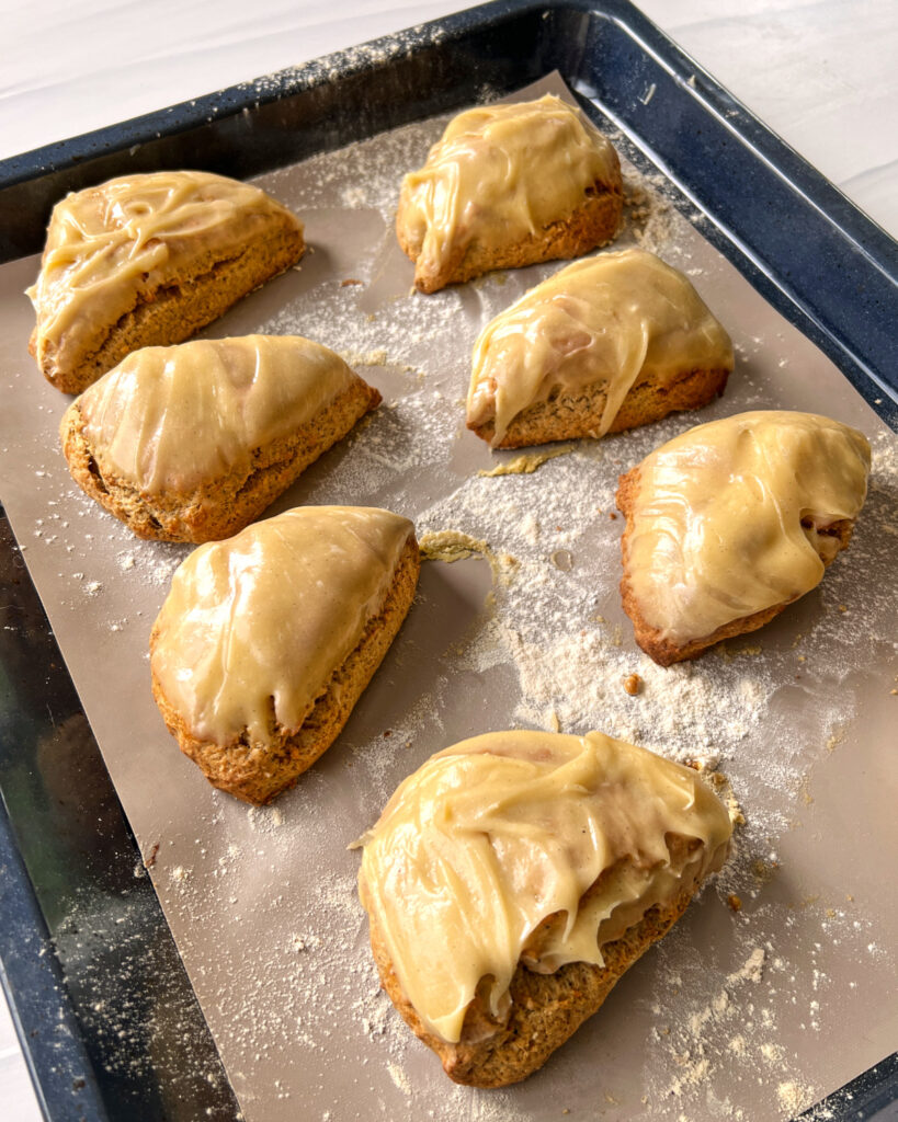 glazed earl grey scones sitting on a baking sheet.