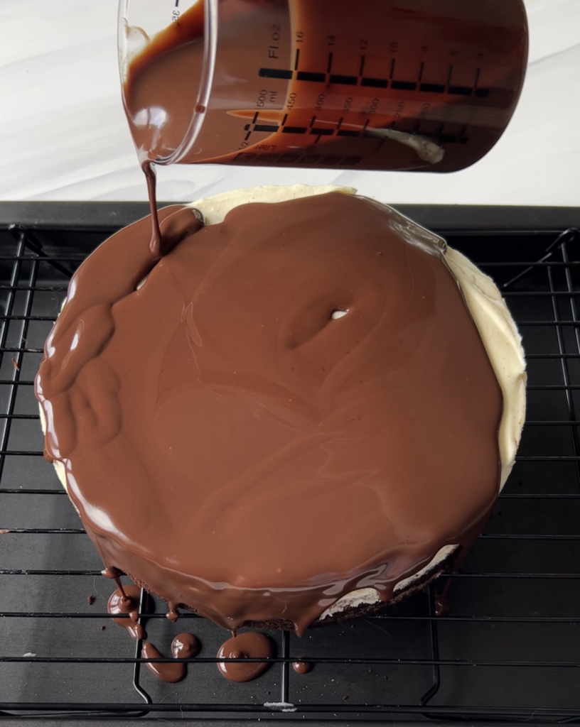Chocolate ganache being poured over black tie mousse cake.