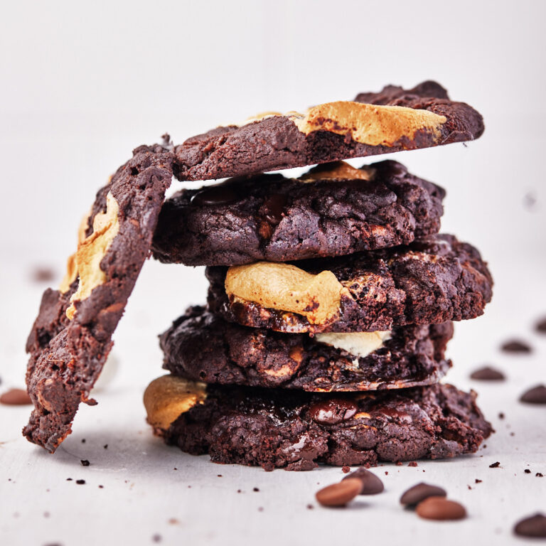 stack of super thick gooey triple chocolate marshmallow cookies.