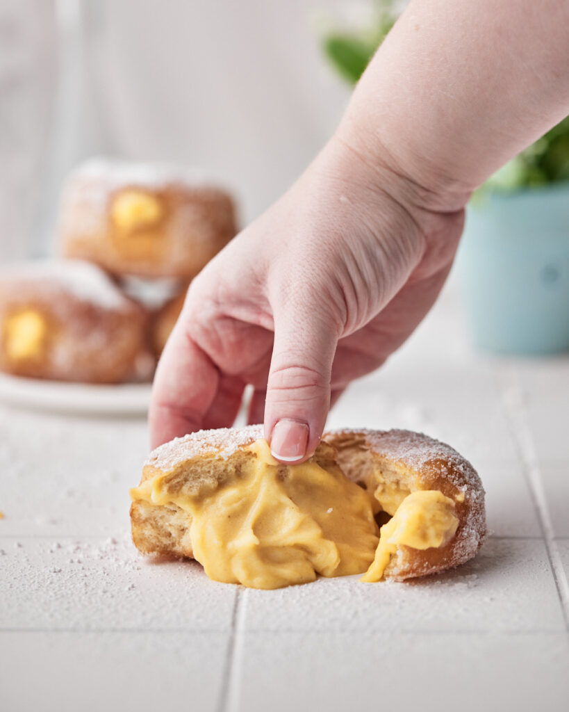 custard filling oozing out of a fried donut.