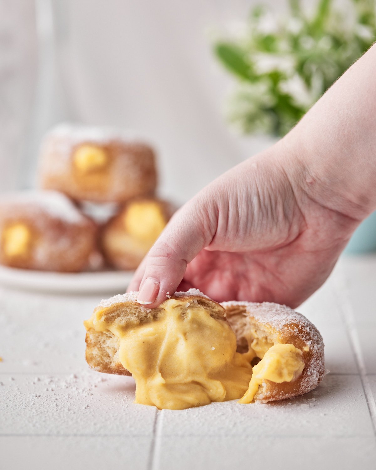 custard filling oozing out of a fried donut.