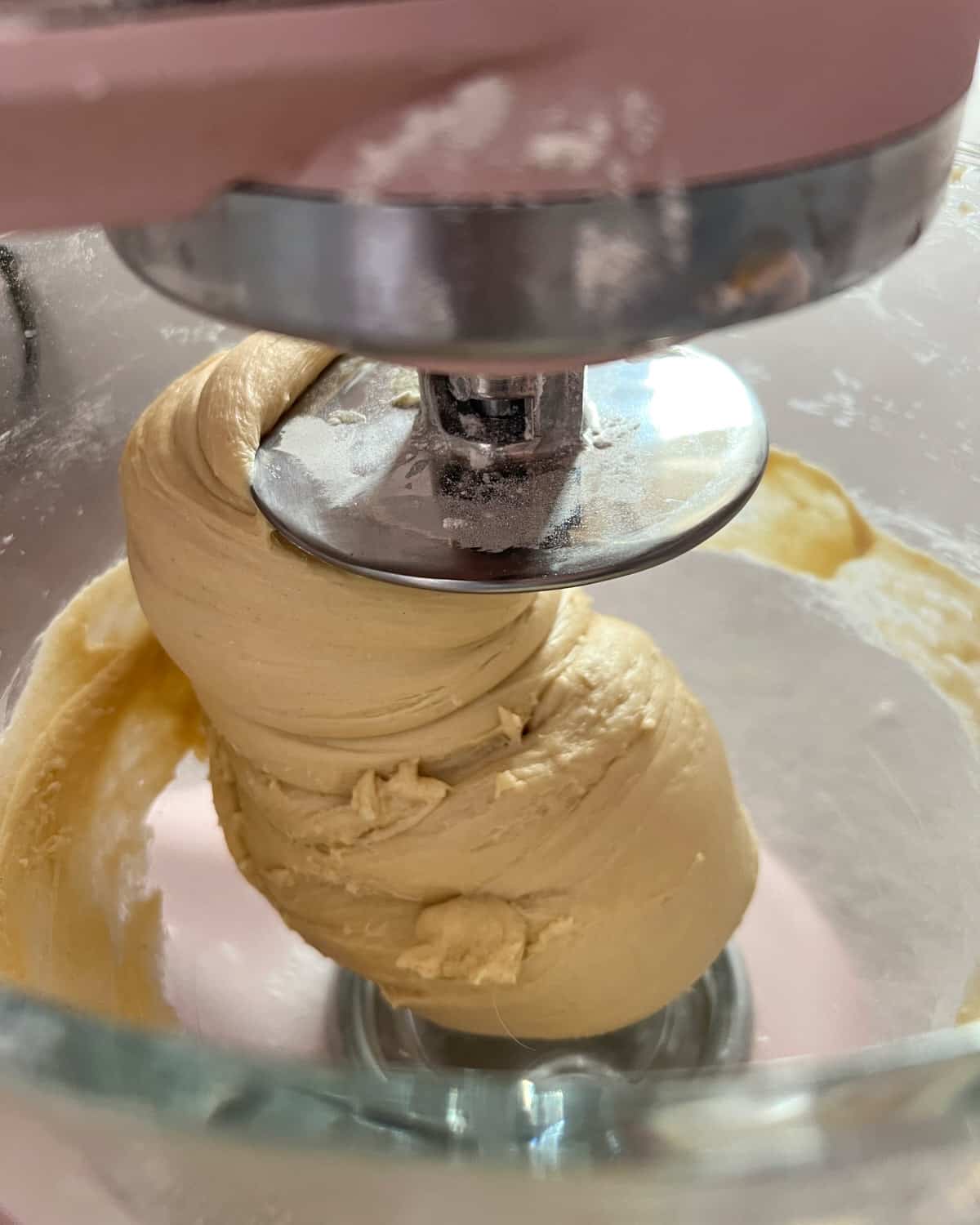 Yeast dough in a stand mixer with a dough hook, kneading the dough to make donuts.