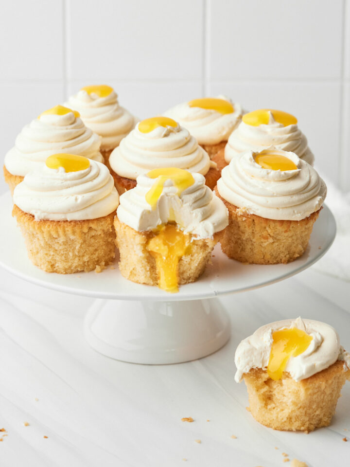 mango cupcakes on a cake stand with mango coulis oozing out the middle.