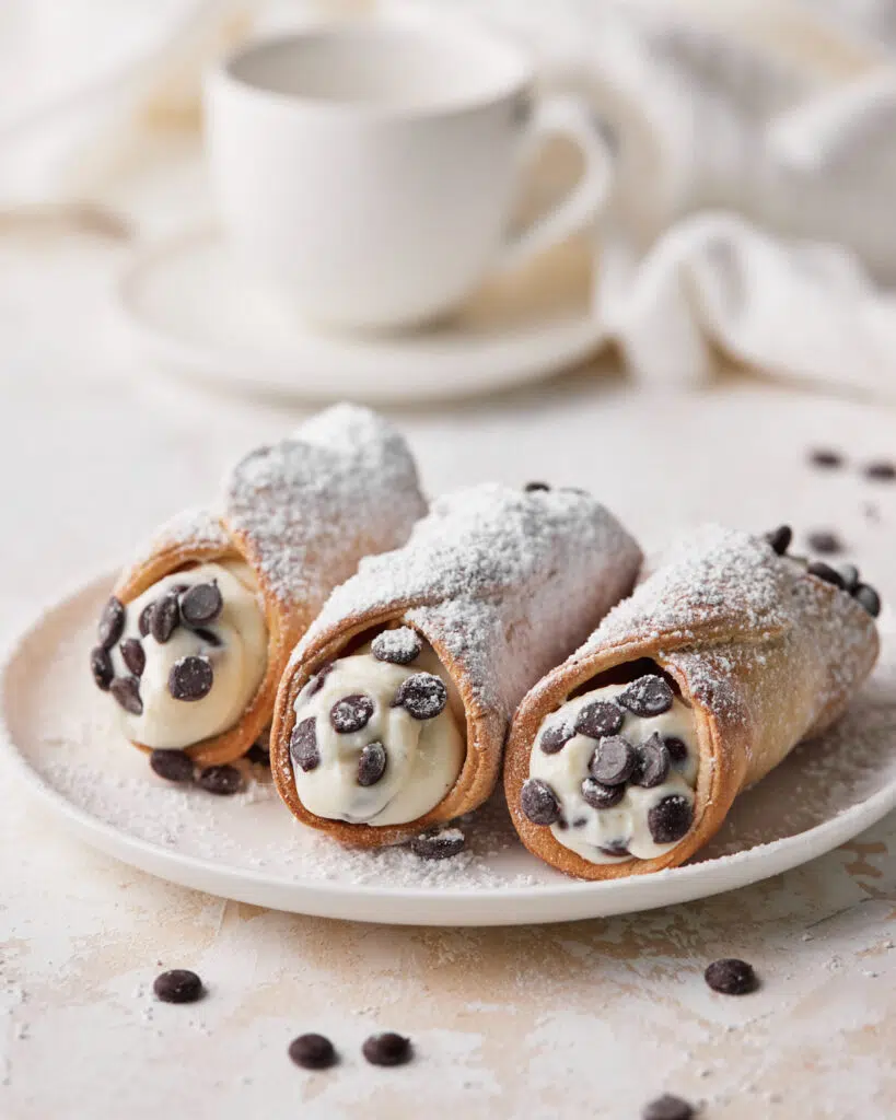 three filled air fryer cannoli on a plate.