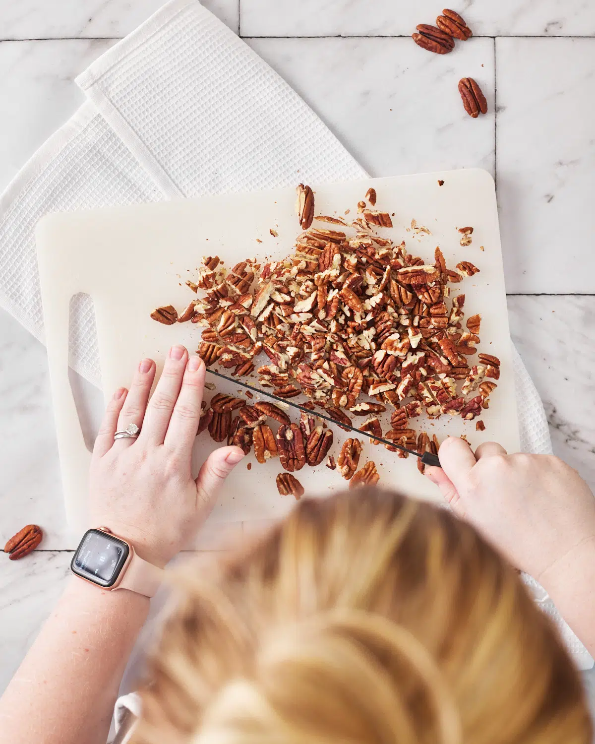 chopping pecans from overhead for brown butter pecan cookies.