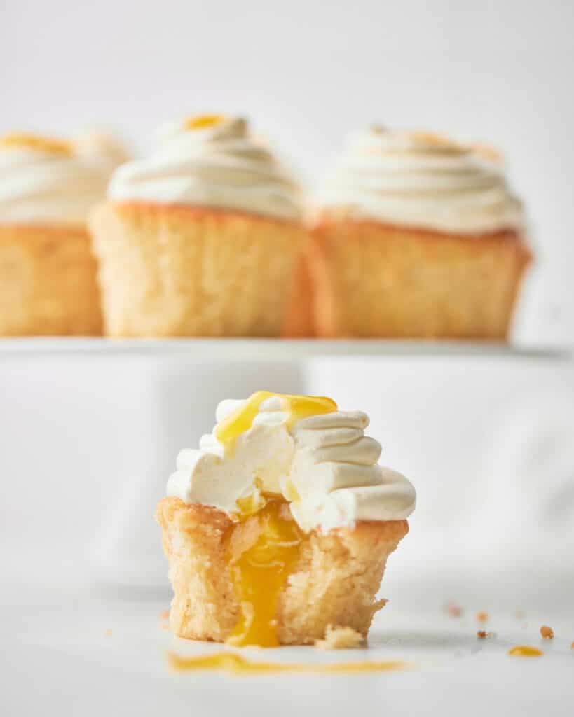 closeup of mango cupcake with a bite taken out to show filling.