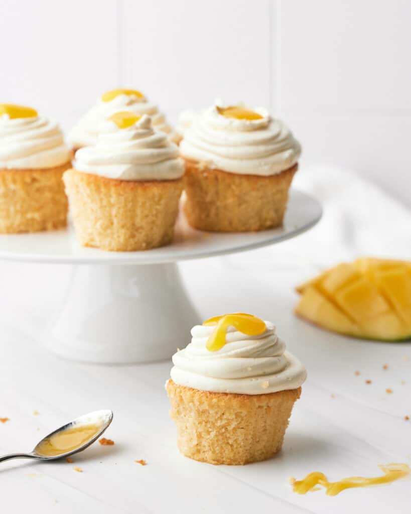mango cupcakes with mango coulis drizzled on top.