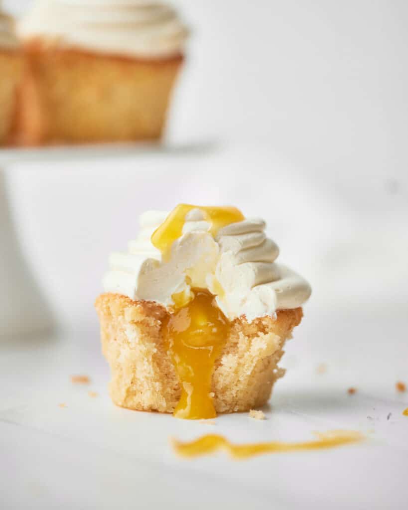 close up of mango cupcake with mango coulis coming out the middle.