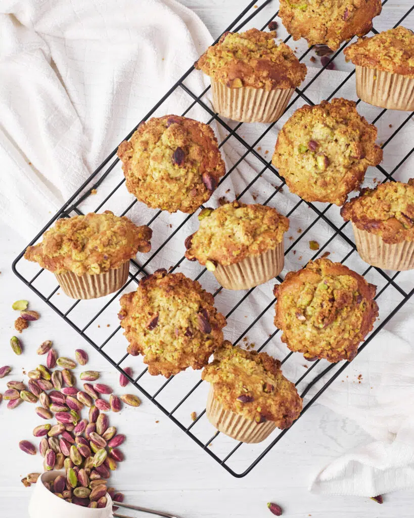 pistachio muffins on a wire rack.