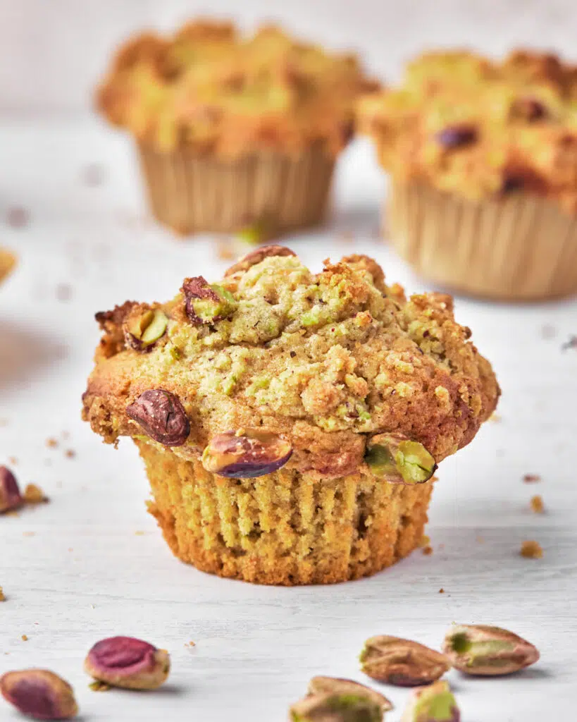 single pistachio muffin with pistachio crumble topping.