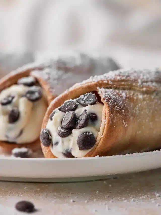 close up of classic cannoli showing the authentic cannoli cream filling and chocolate chips inside.