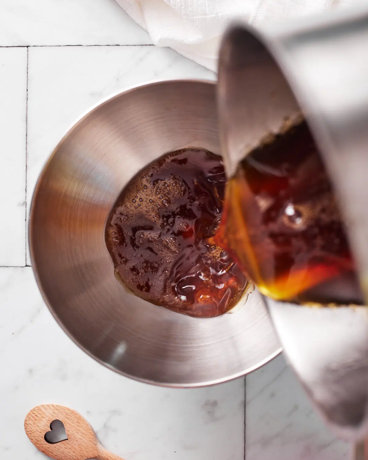 pouring hot maple syrup into bowl to make maple cream.