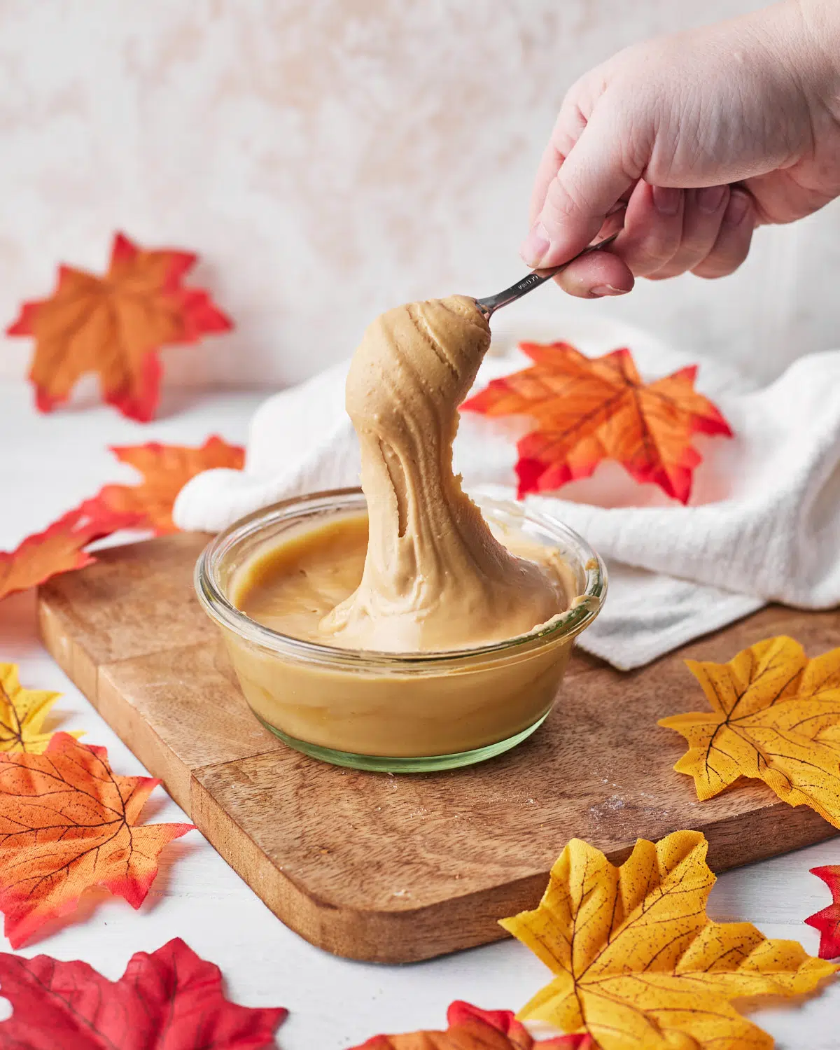 thick maple cream being spooned out of jar. 