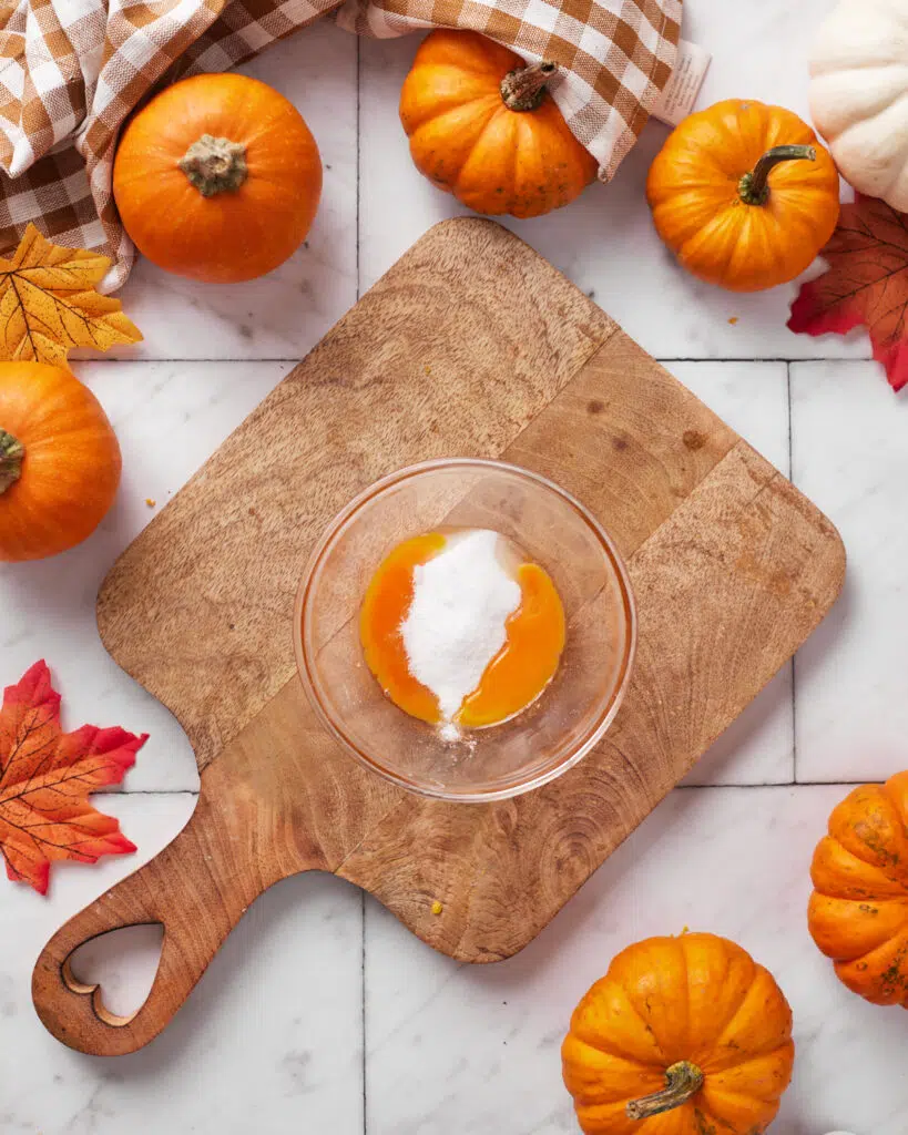 egg yolks and sugar in a bowl for pumpkin creme brulee.