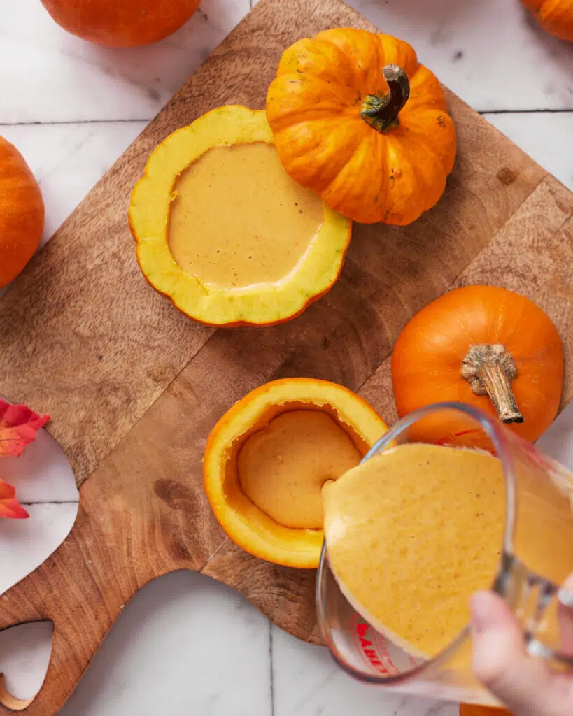hollowed mini pumpkins being filled with pumpkin creme brulee.