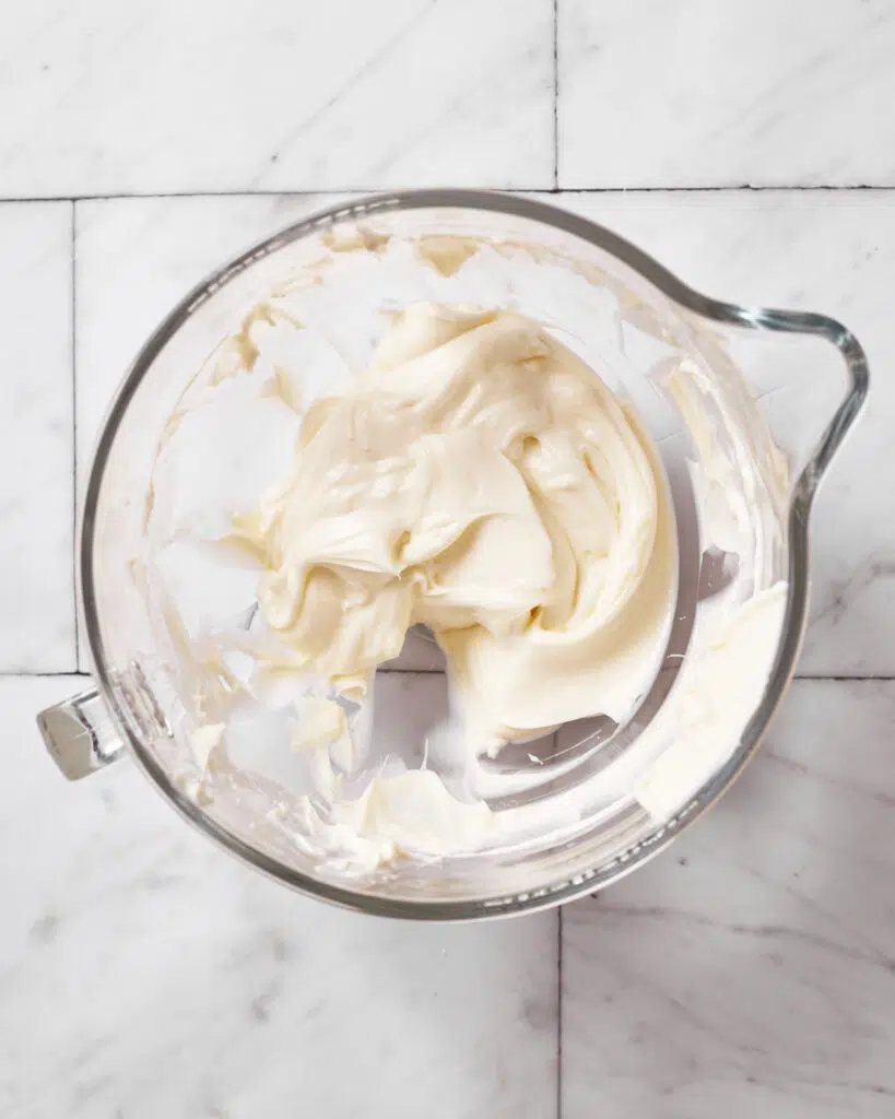 Process shot of cream cheese and sugar mixed together to make basque cheesecake. 