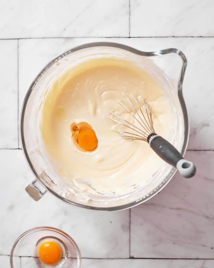 Eggs being added to cheesecake batter for burnt basque cheesecake.