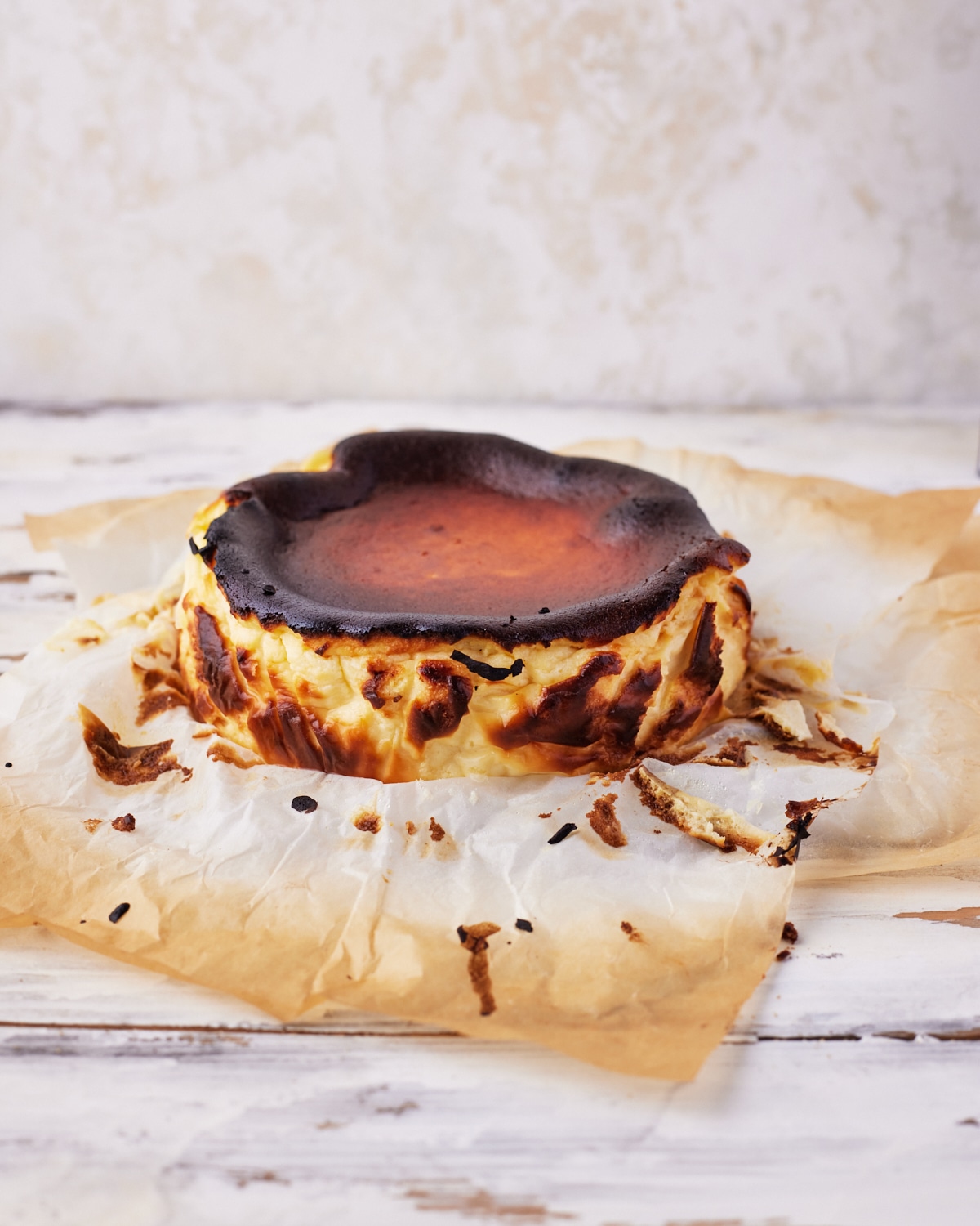 burnt basque cheesecake with the parchment paper removed to show caramelized sides. 