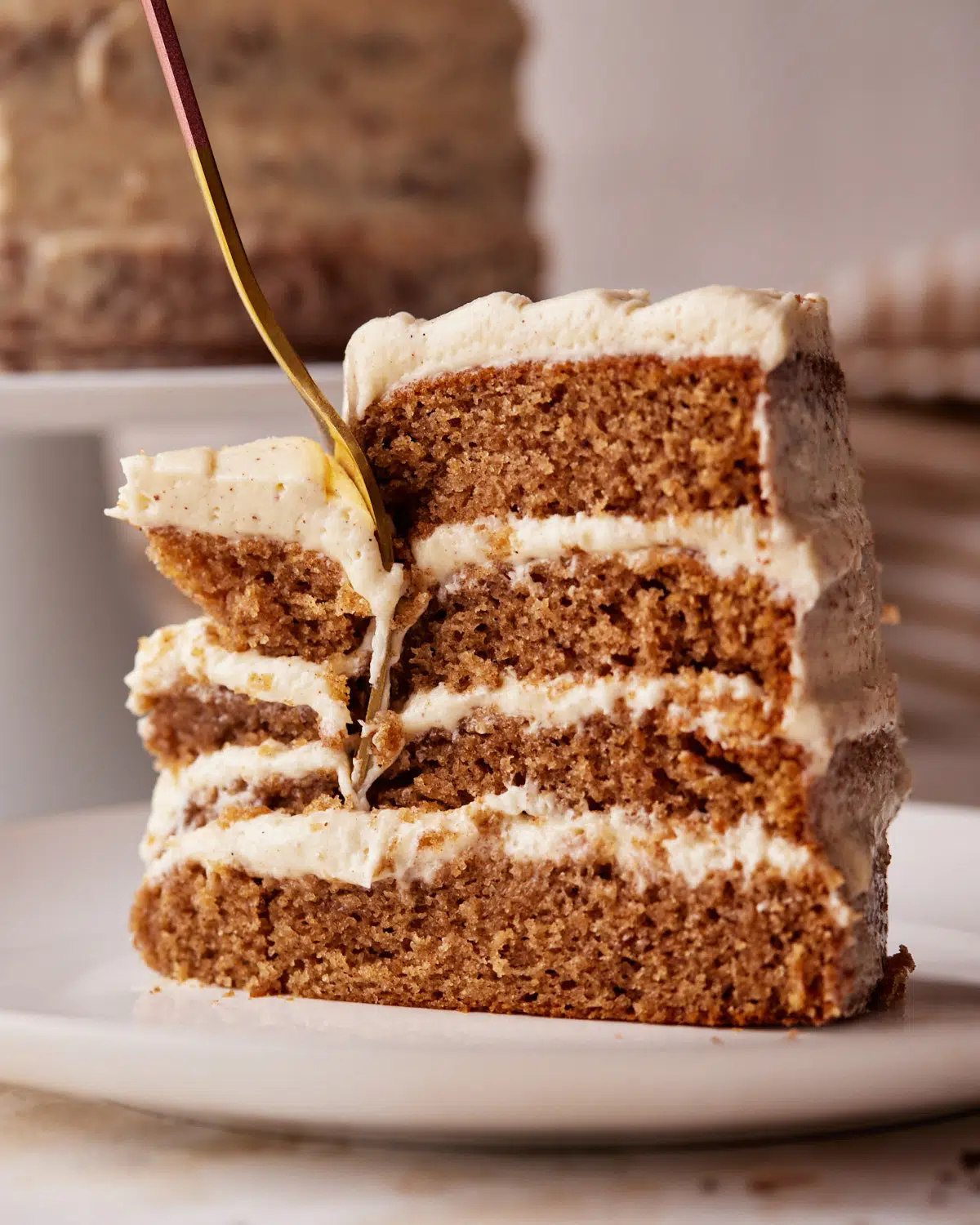 slice of chai cake with four layers being sliced.