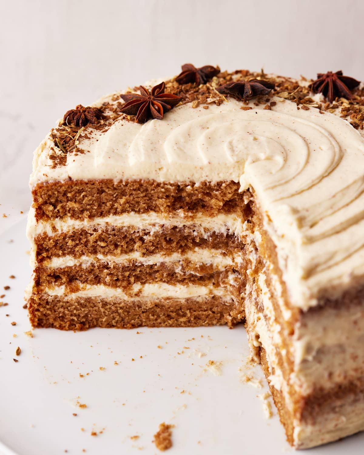 chai cake with brown butter frosting with a quarter cut out of it. 