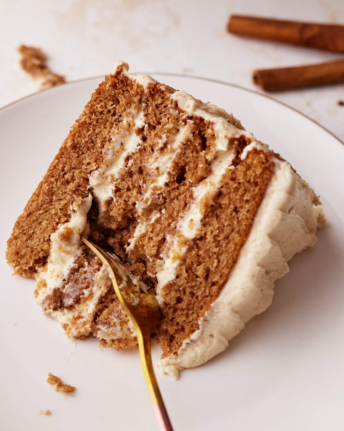 slice of chai cake on its side with brown butter cream cheese frosting.