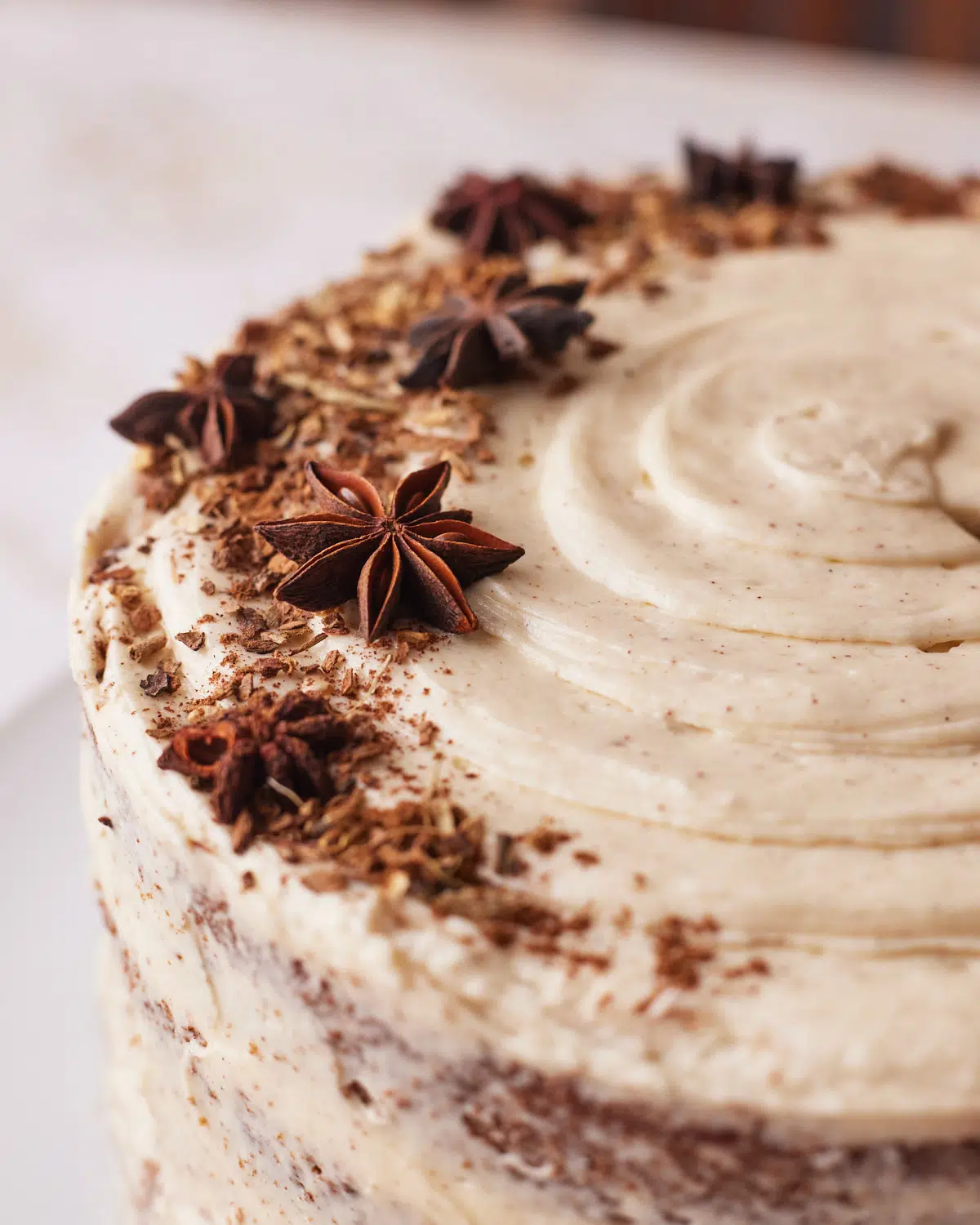 top of chai cake decorated with brown butter frosting, cinnamon and star anise.