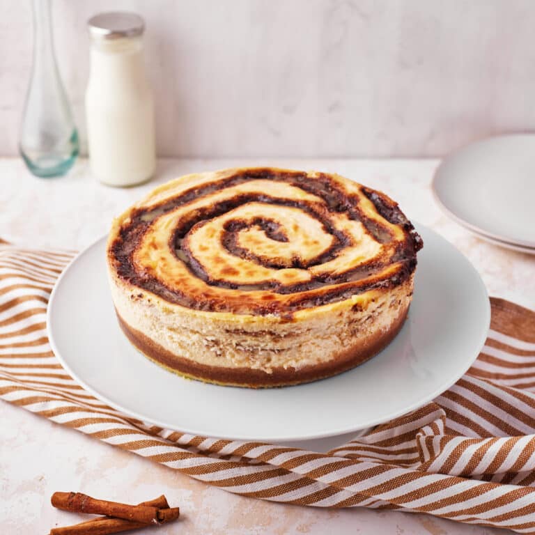 cinnamon roll cheesecake with a cinnamon swirl baked into the top.