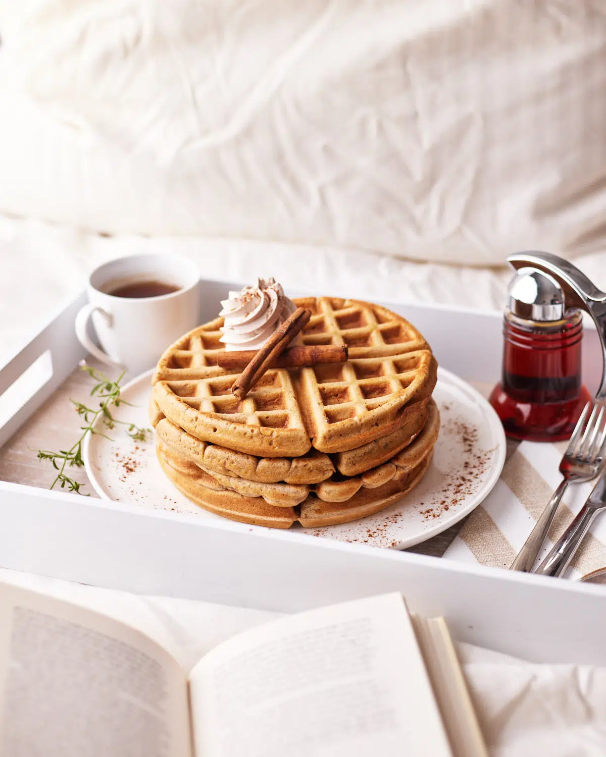 cinnamon whipped cream on top of cinnamon waffles on a serving tray.