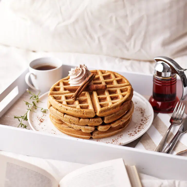 cinnamon waffles being served on a tray in bed.
