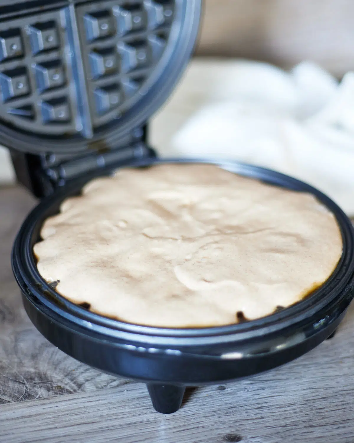 raw cinnamon waffle batter going into waffle maker.