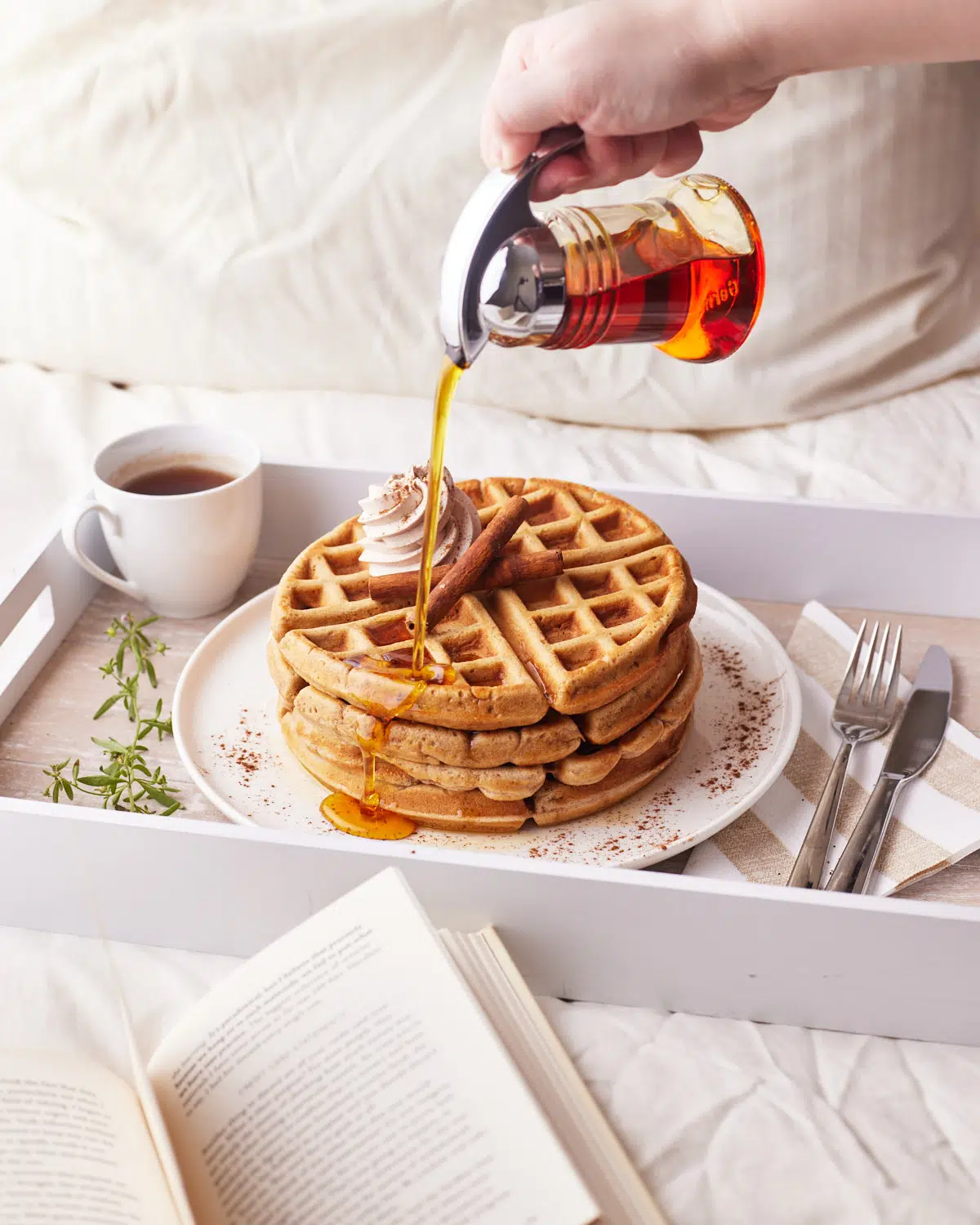 maple syrup being poured on cinnamon waffles. 