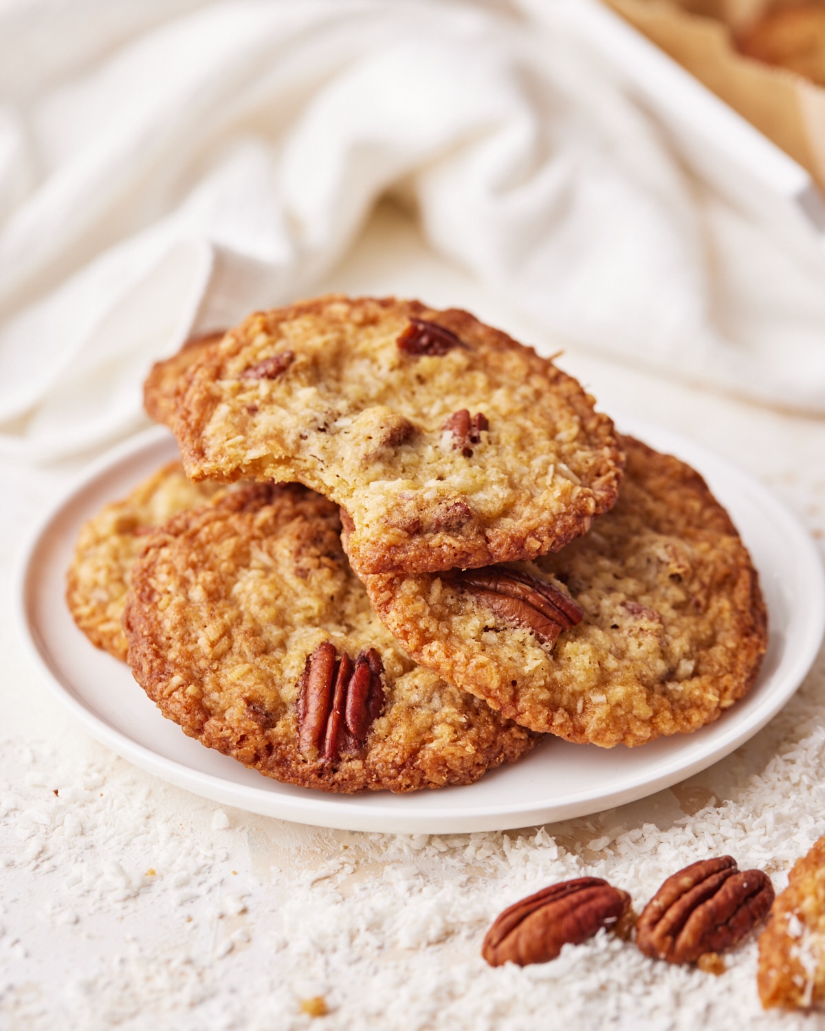 Four coconut pecan cookies on a plate. 