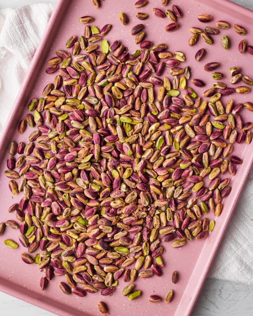 pistachios on a cookie sheet ready for roasting.