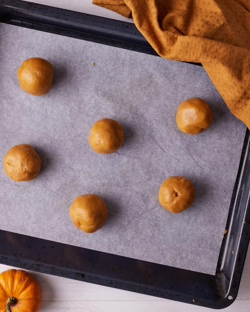 pumpkin cheesecake cookies on a cookie sheet ready to bake.