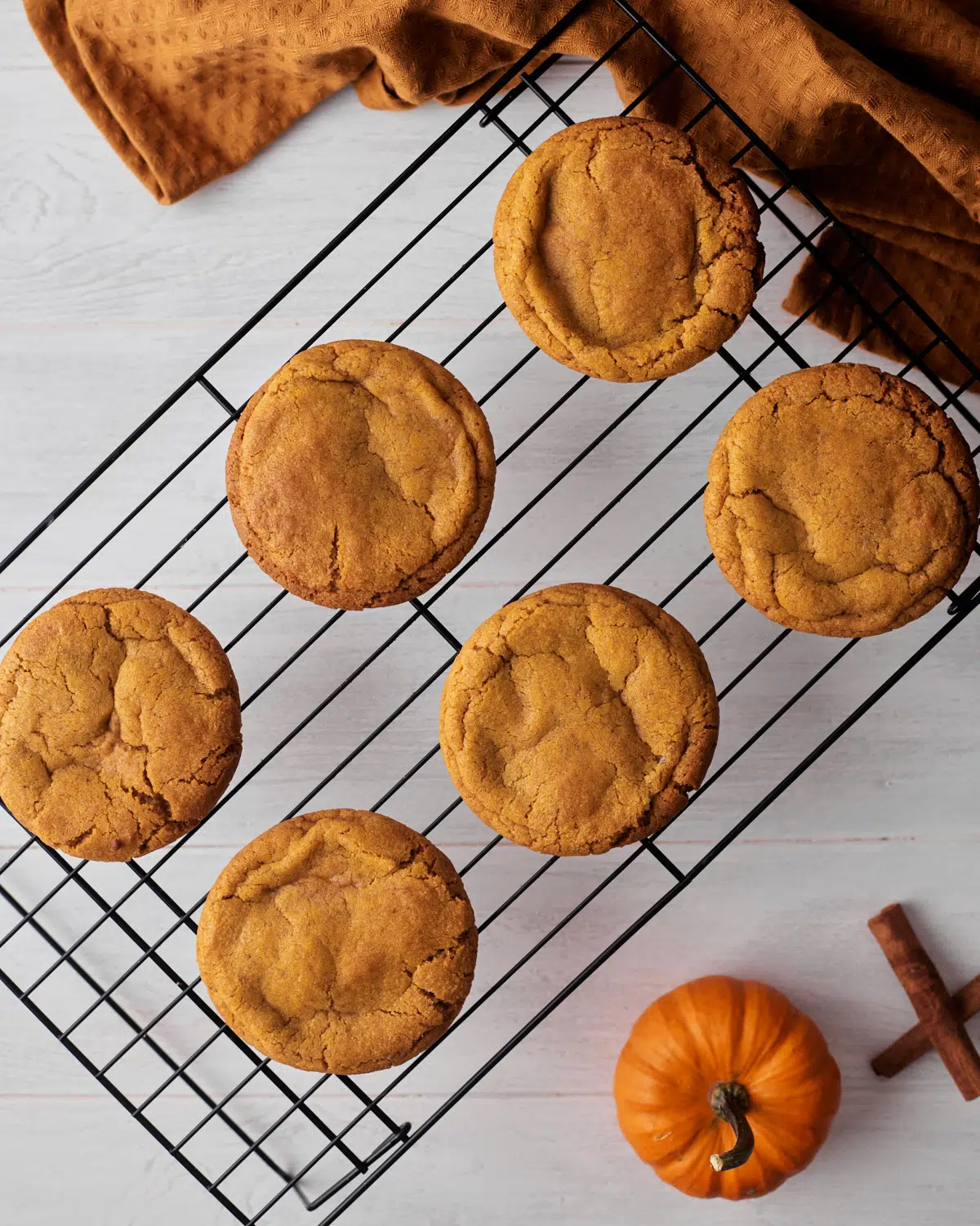 pumpkin cheesecake cookies cooling on a wire rack. 