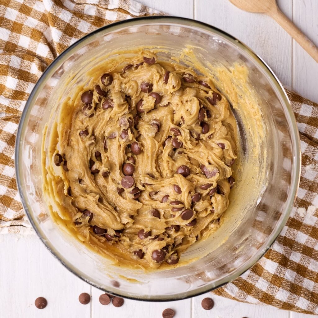 Bowl of edible cookie dough on a brown tea towel.
