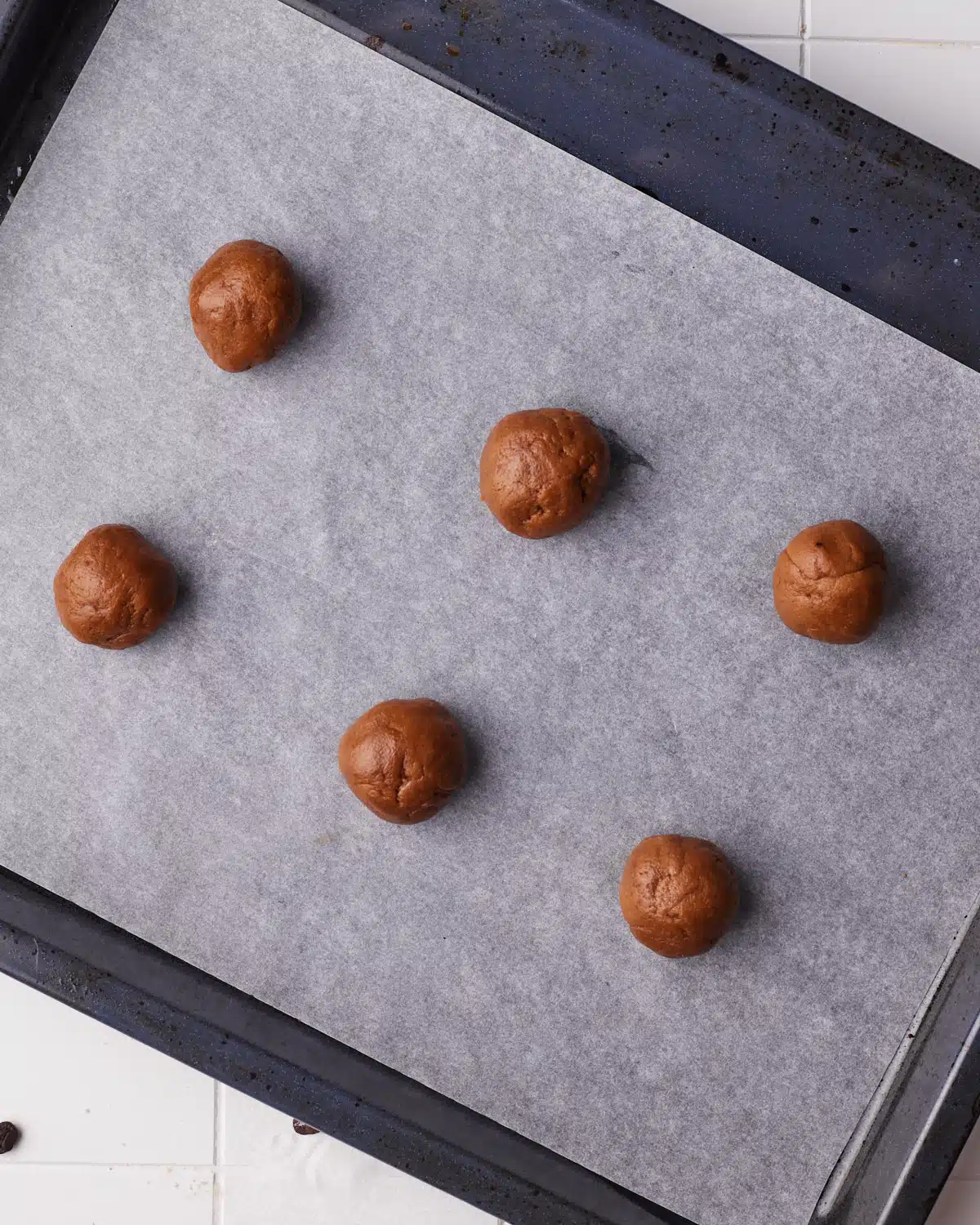 coffee cookie dough balls on a baking sheet ready to be baked. 