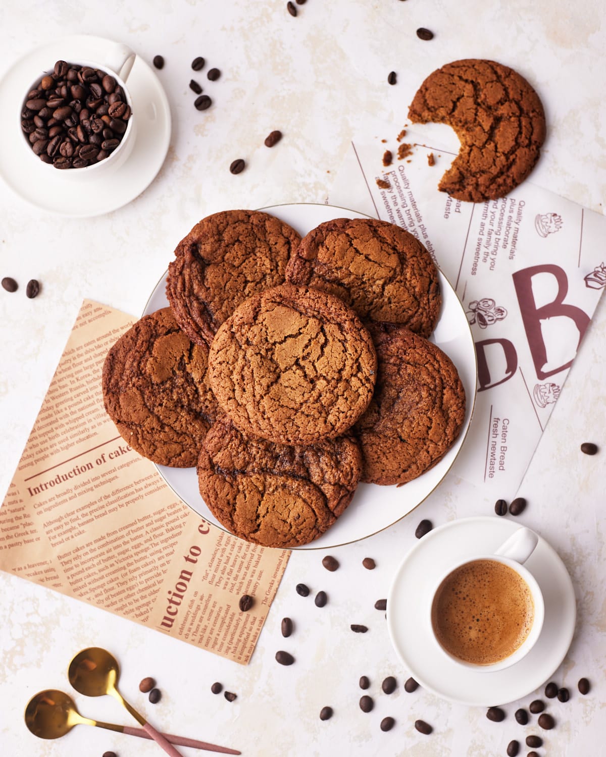 coffee cookies in a pile on a plate, surrounded by coffee beans and espresso.