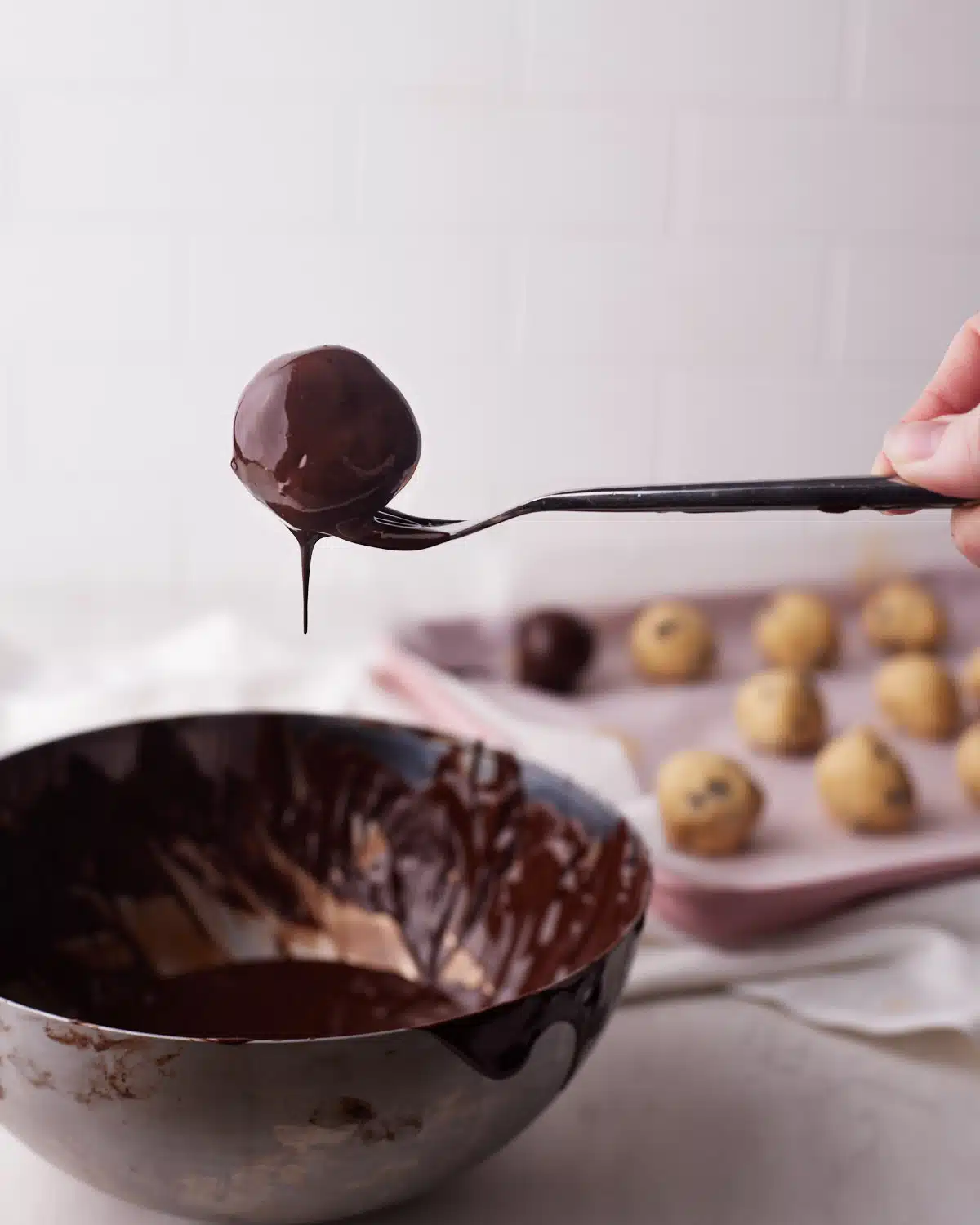 dipping cookie dough bites in melted chocolate.