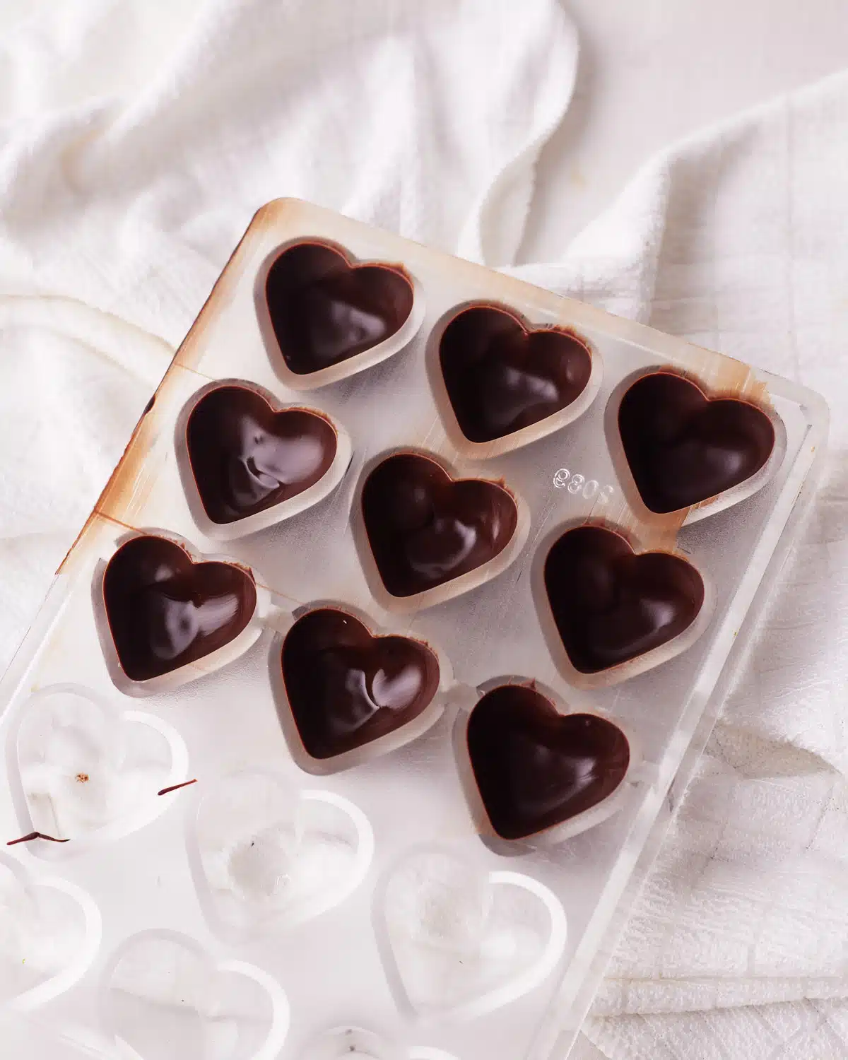 putting chocolate in a heart shaped mold to make cookie dough bites.