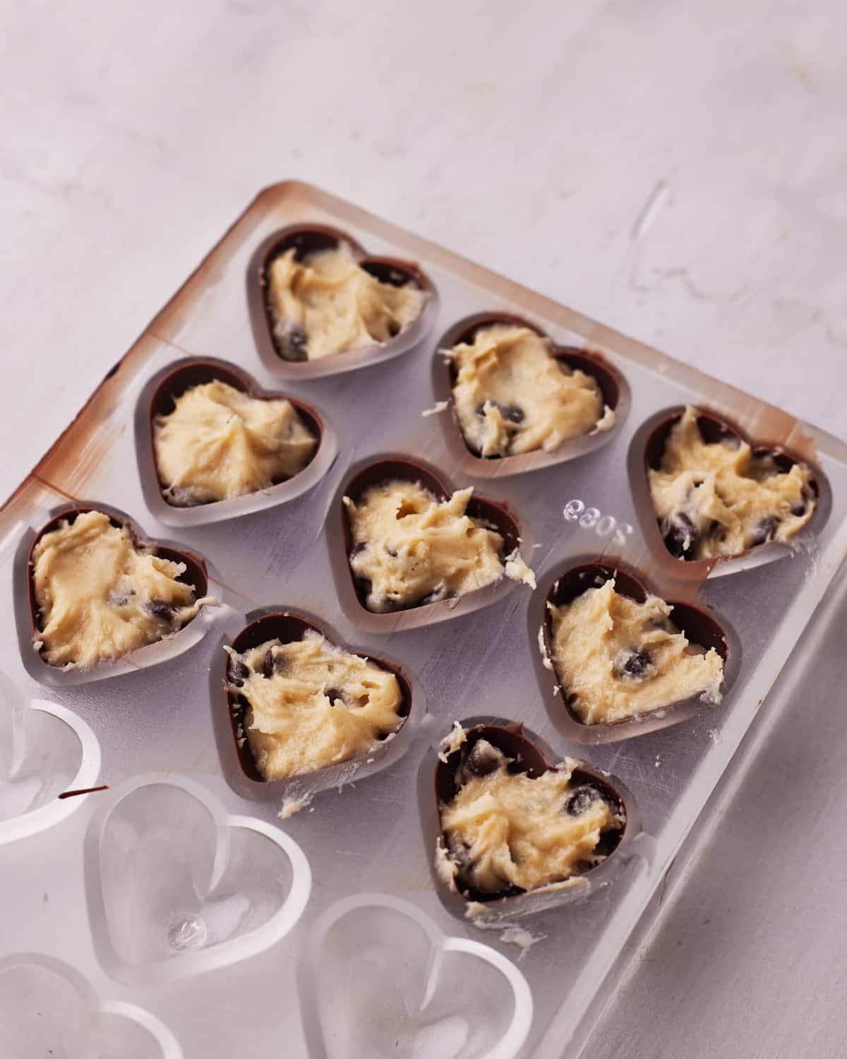 making cookie dough bites in a heart shaped mold.