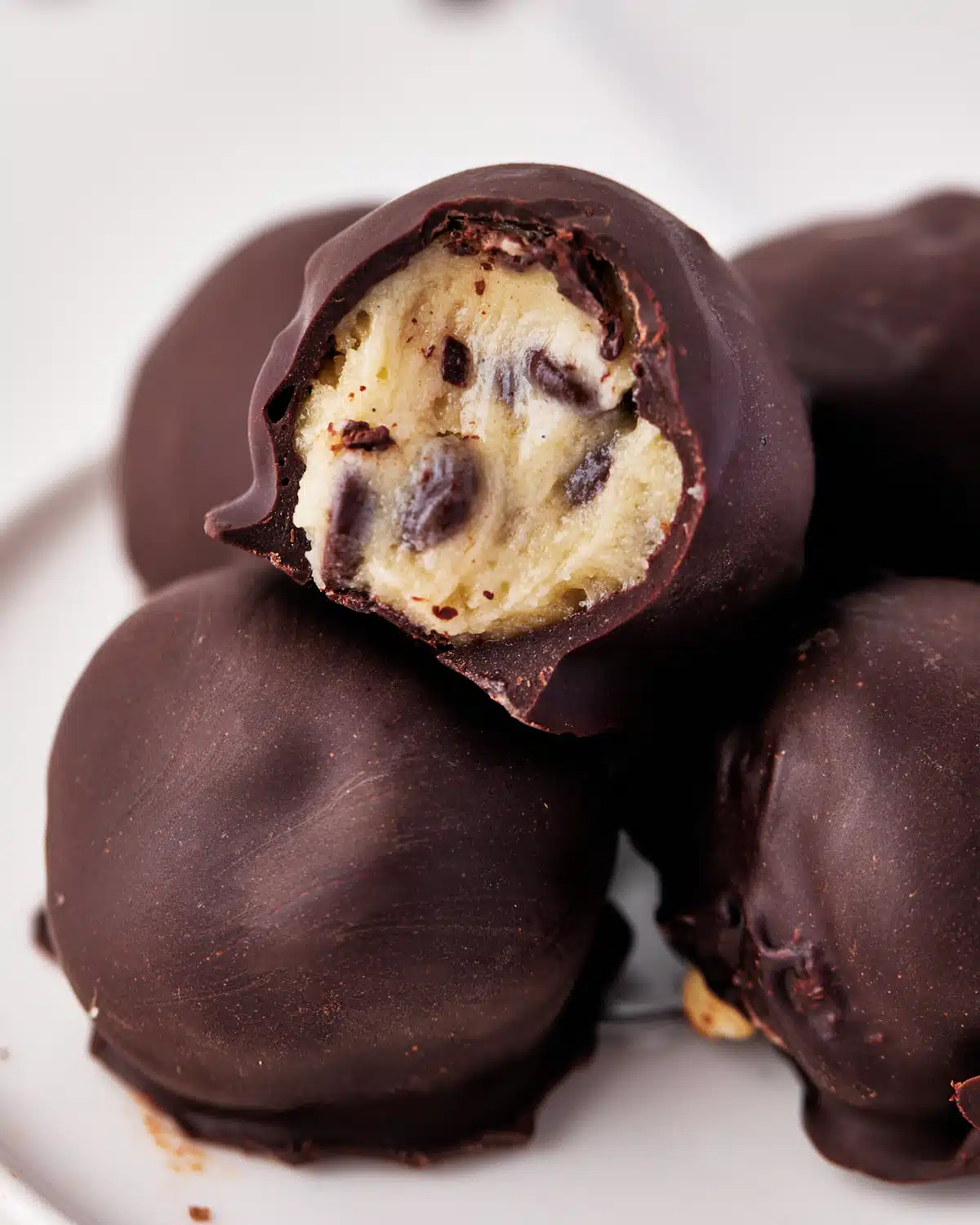 close up of edible cookie dough bites covered in chocolate.