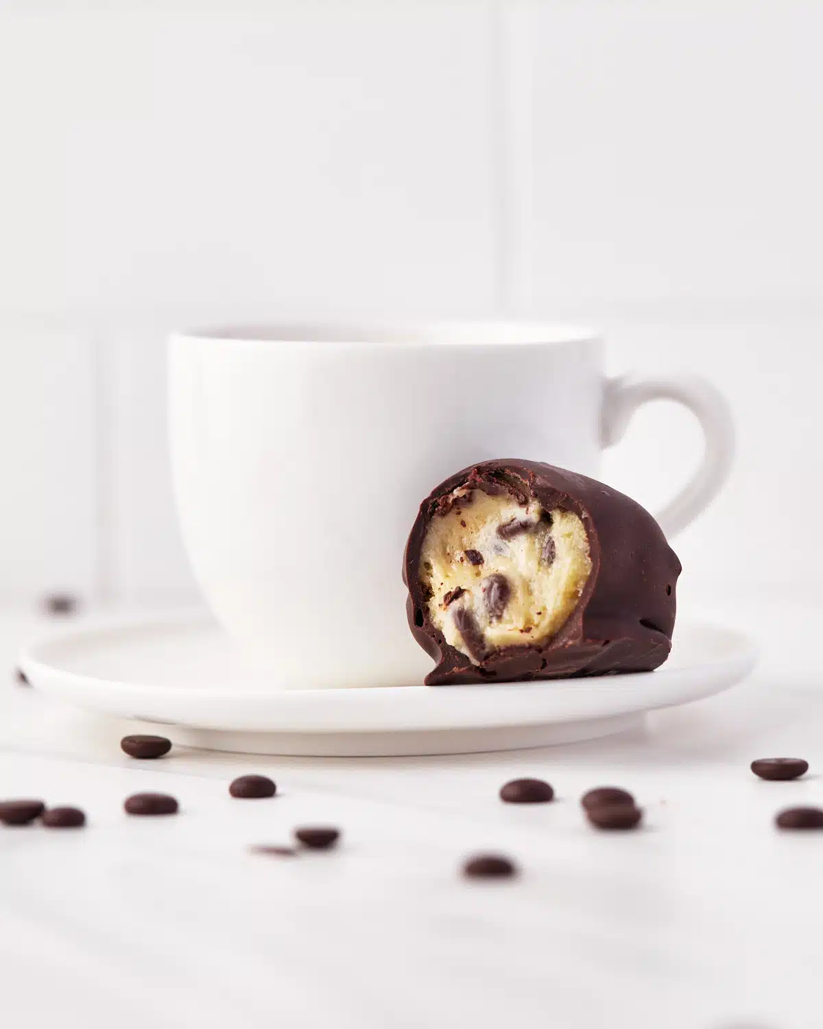 single cookie dough bite on a saucer with a cup of tea. 