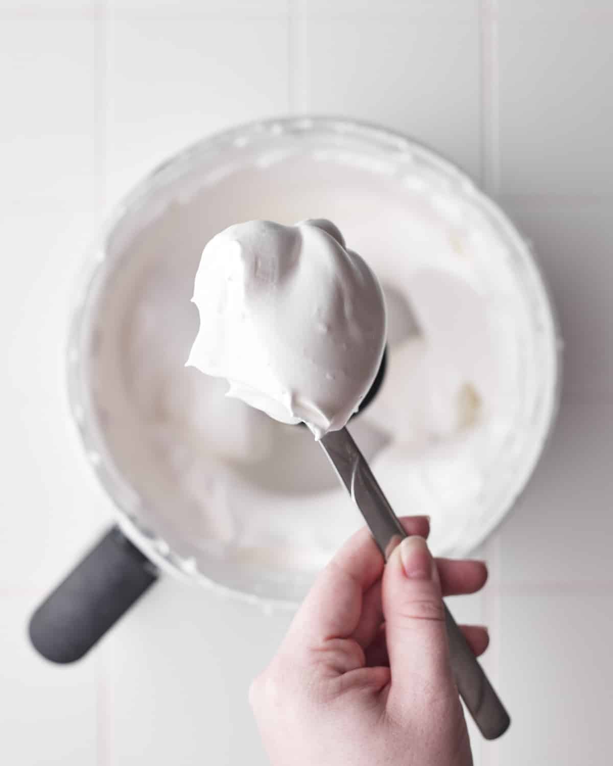 meringue whipped to stiff peaks on a spoon to show thickness.