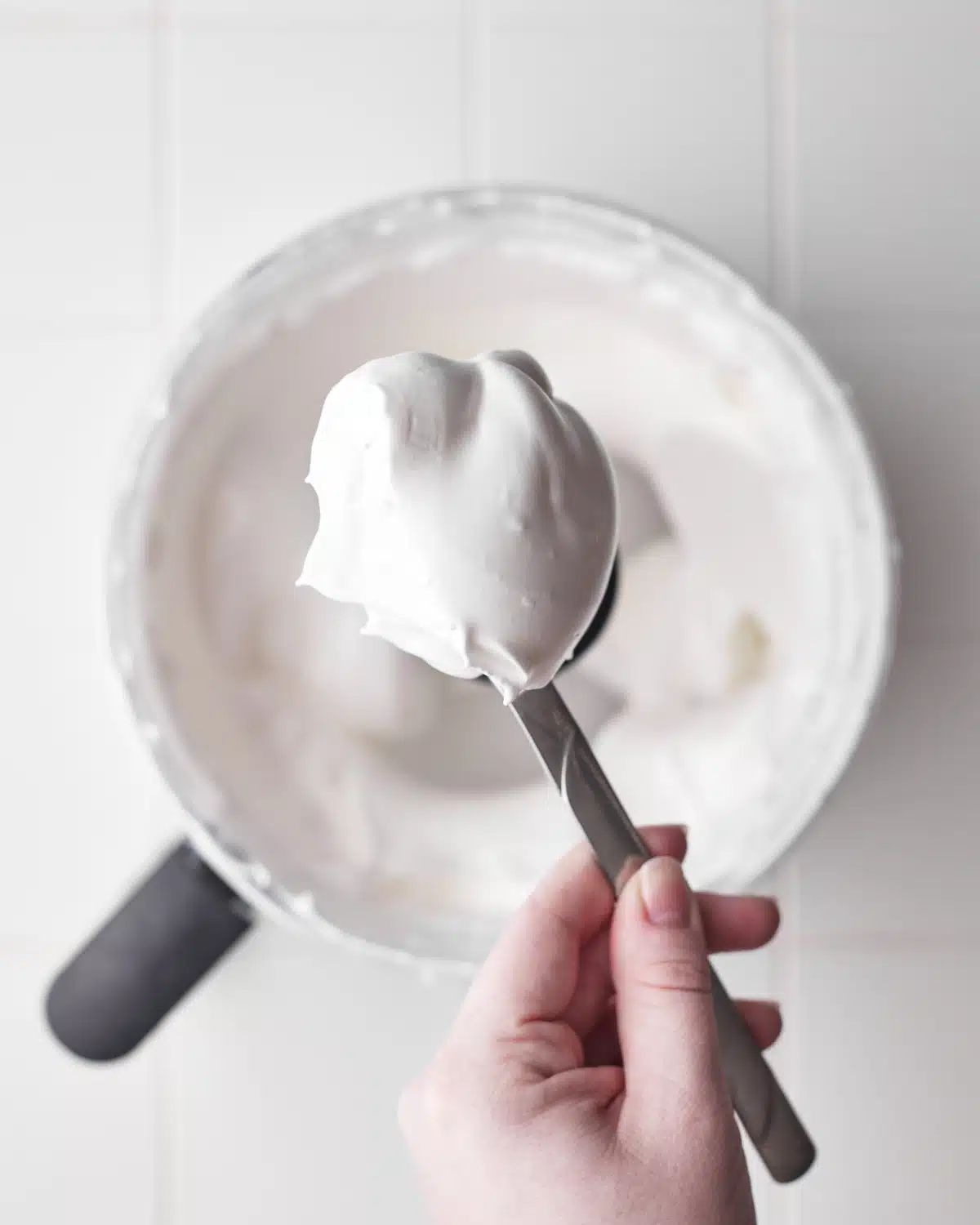 meringue whipped to stiff peaks on a spoon to show thickness.