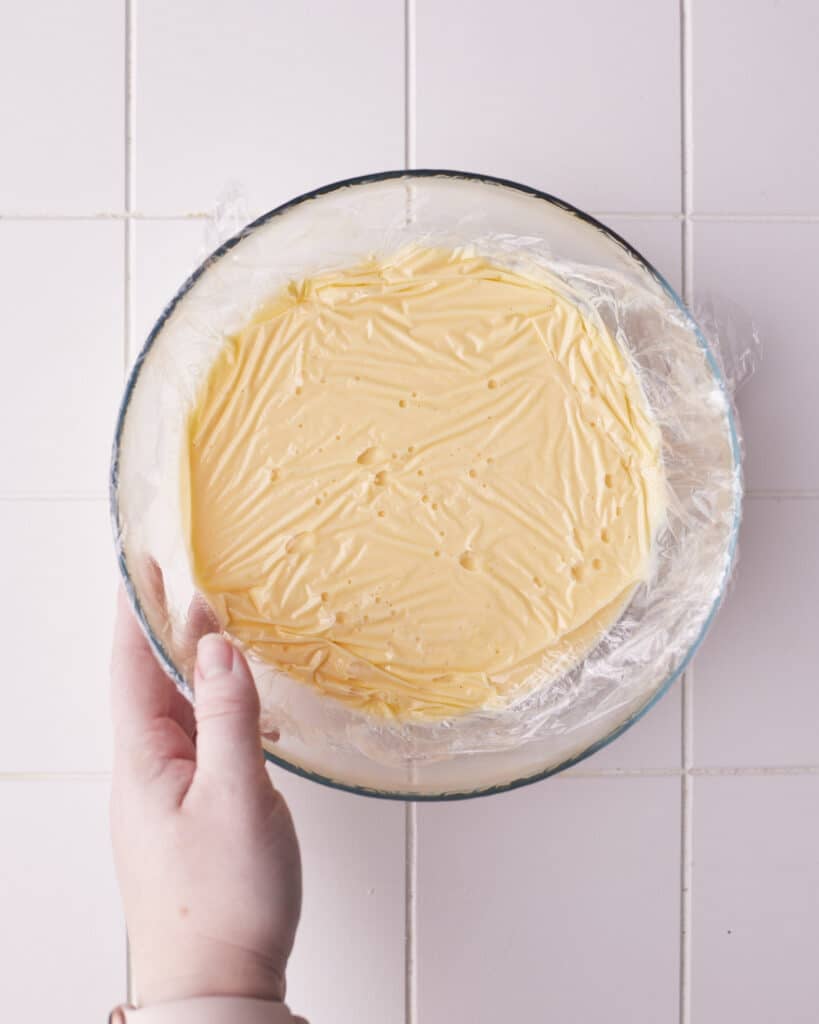 creme anglaise covered with plastic wrap for floating island dessert.