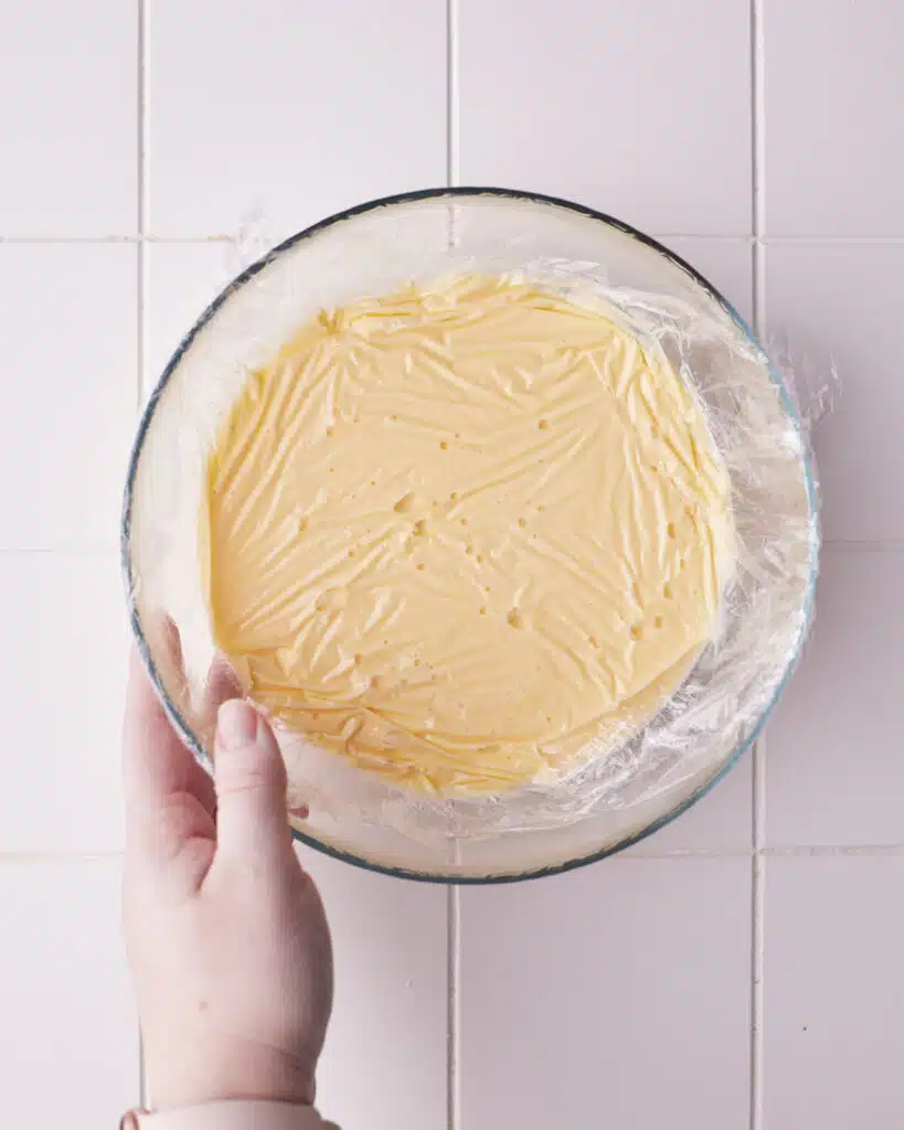 creme anglaise covered with plastic wrap for floating island dessert.