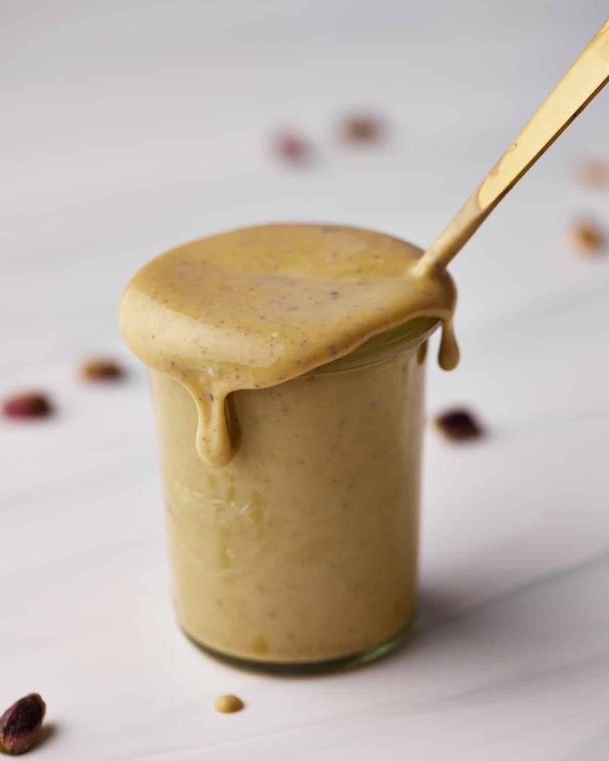 pistachio cream in a jar, dripping over the edge. 